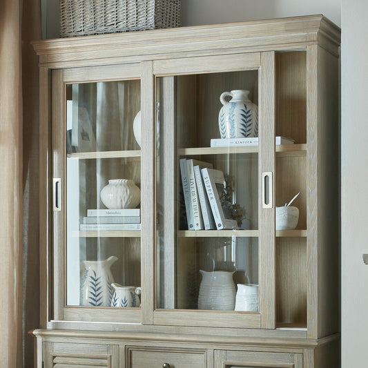 Wooden display cabinet with glass doors containing decorative items.