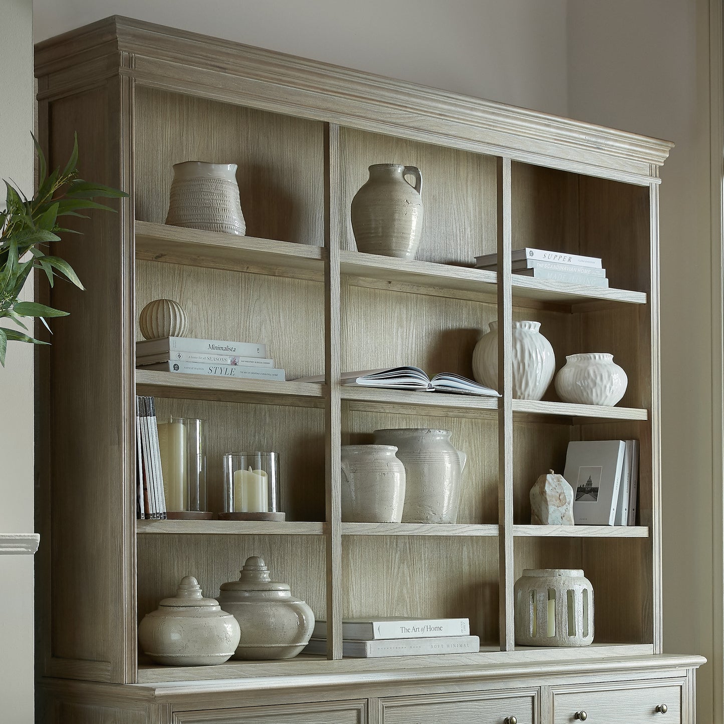 Wooden bookshelf with decorative items against a neutral wall