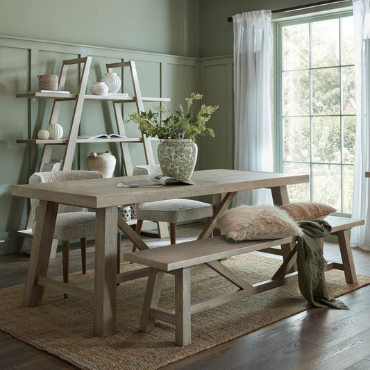 Dining room with wooden table, chairs, and bench in a well-lit room.