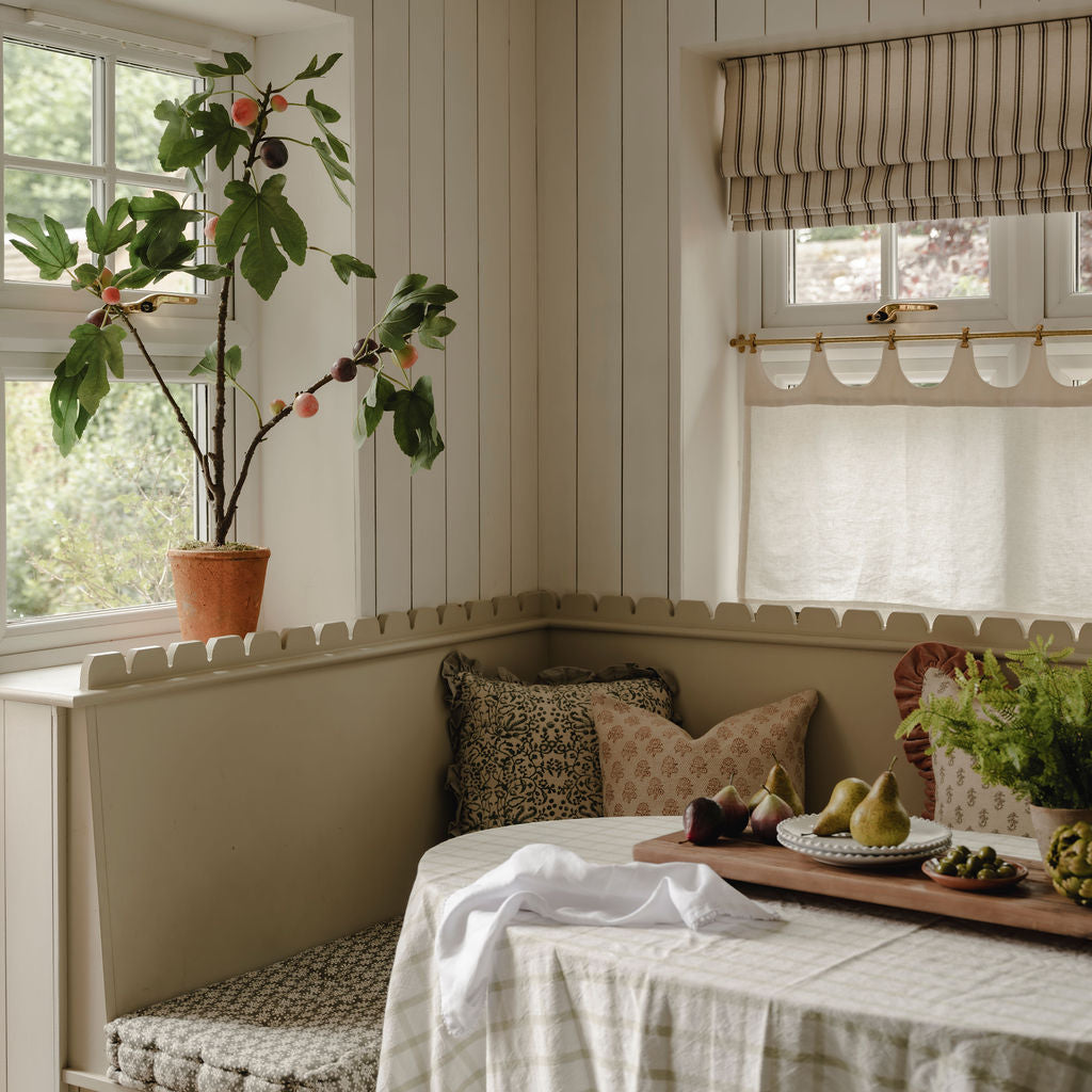 Nook with a table, cushions, and decorative items in a home setting