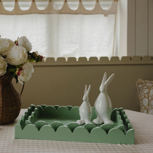 Decorative tray with white rabbit figurines on a table in a home setting.