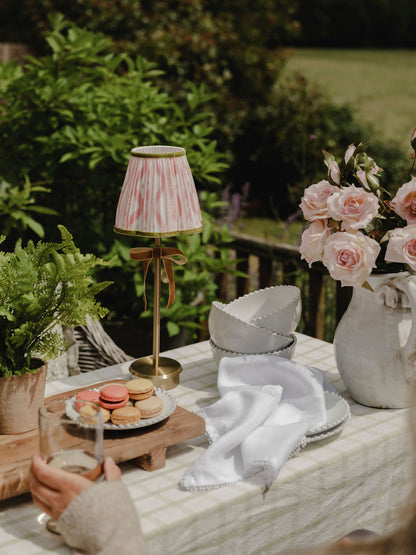 Outdoor setting with a table featuring a lamp, macarons, and flowers.