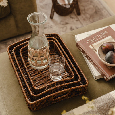 Ashford faux rattan trays styled with a glass carafe and books