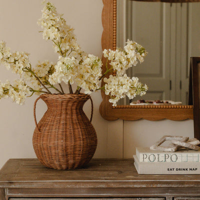 Woven wicker vase with white blossom
